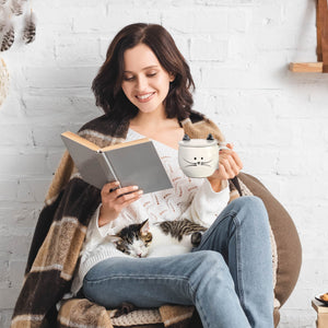 Girl reading with cute cat mug