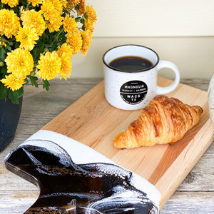 Acacia Resin Cheeseboard with coffee and croissant.