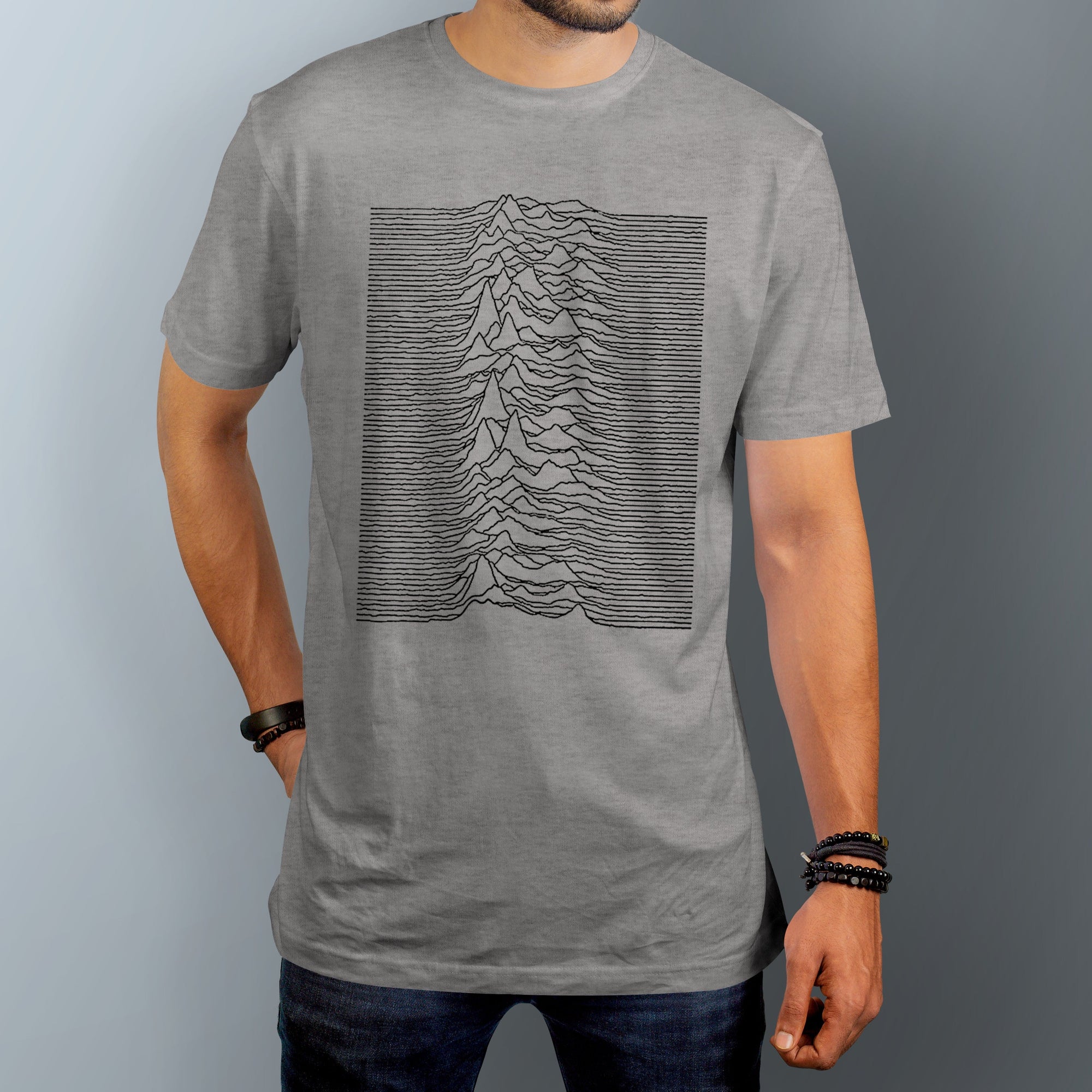 Man wears Joy Division Unknown Pleasures graphic t-shirt in gray. 