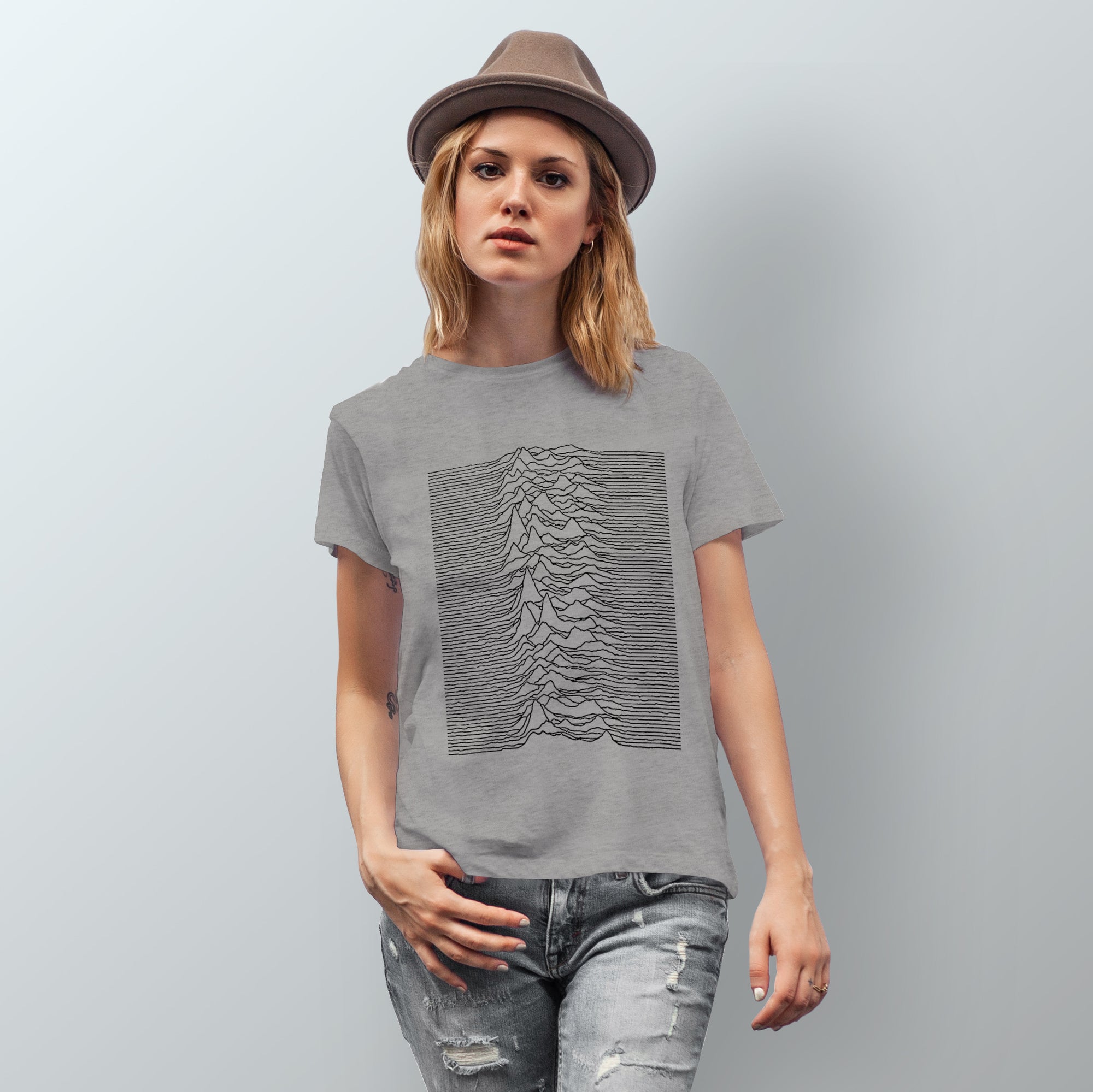 Woman wears Joy Division Unknown Pleasures graphic t-shirt in gray. 