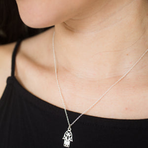 Sterling Silver charm of hamsa hand on necklace, from India shown in medium closeup on model.