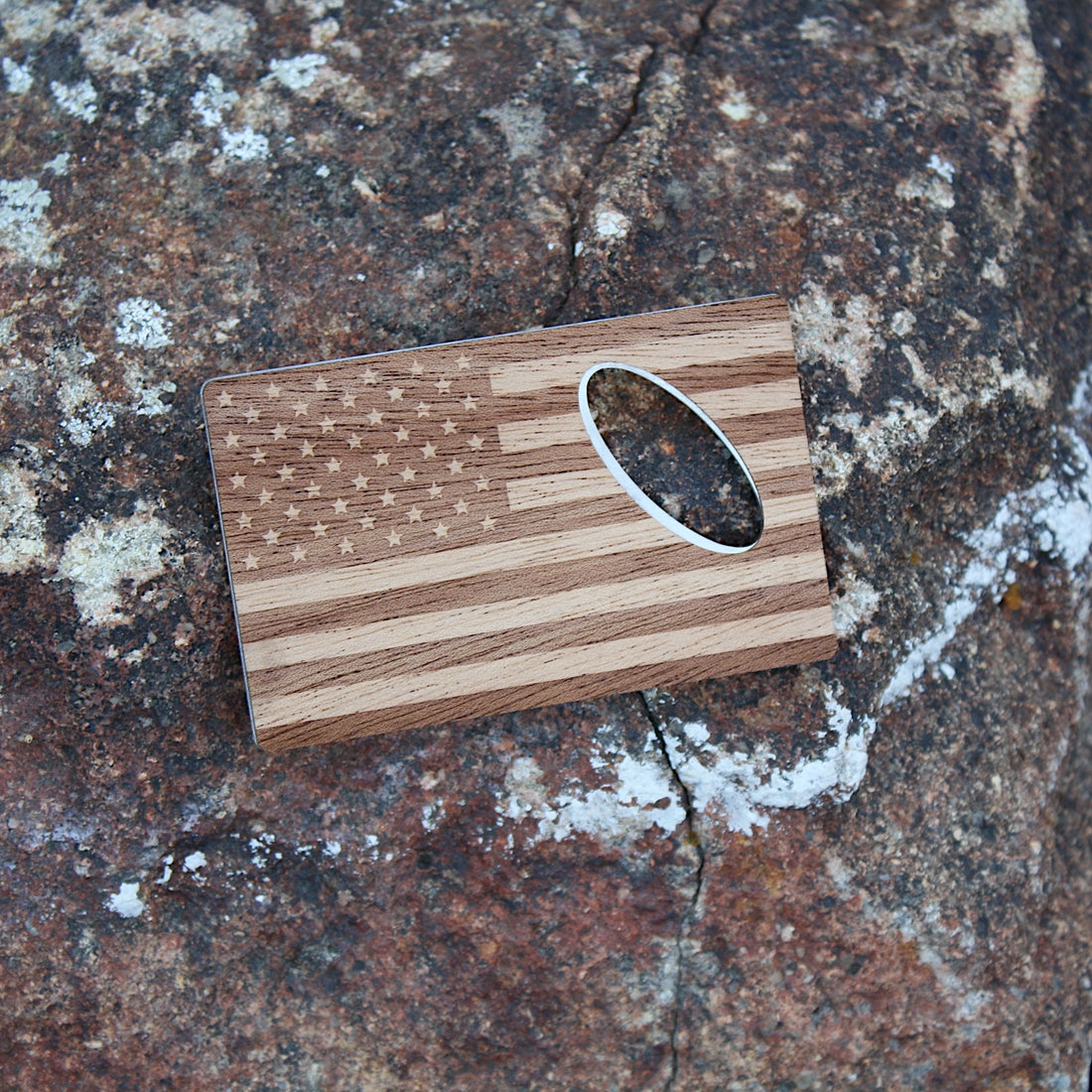 American Flag Wooden credit card bottle opener on a rock.