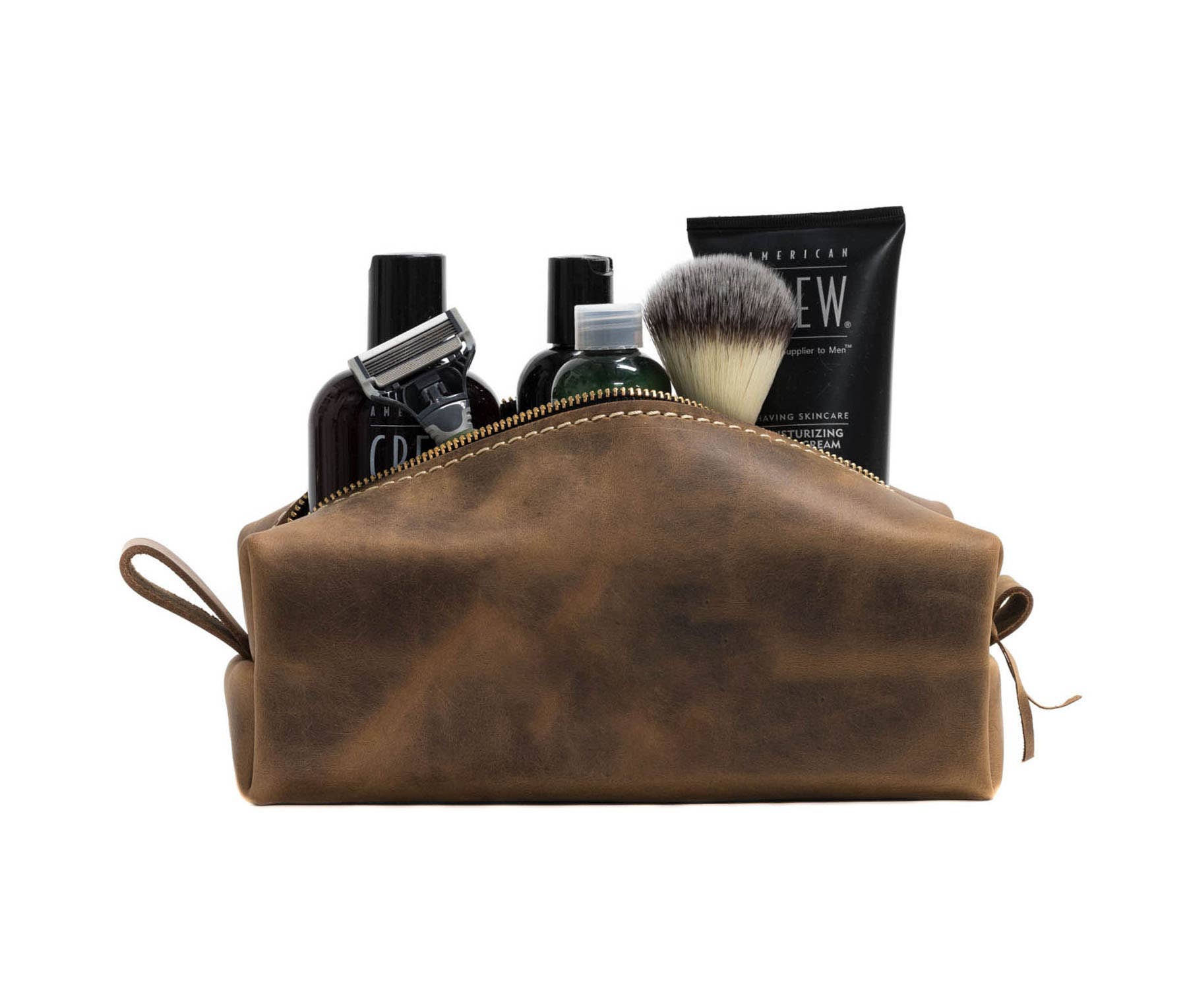 Leather dopp kit in Desert Sand color with items inside.