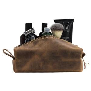 Leather dopp kit in Desert Sand color with items inside.