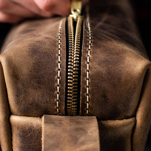 Leather dopp kit closeup of the zipper closure, in color Desert Sand.