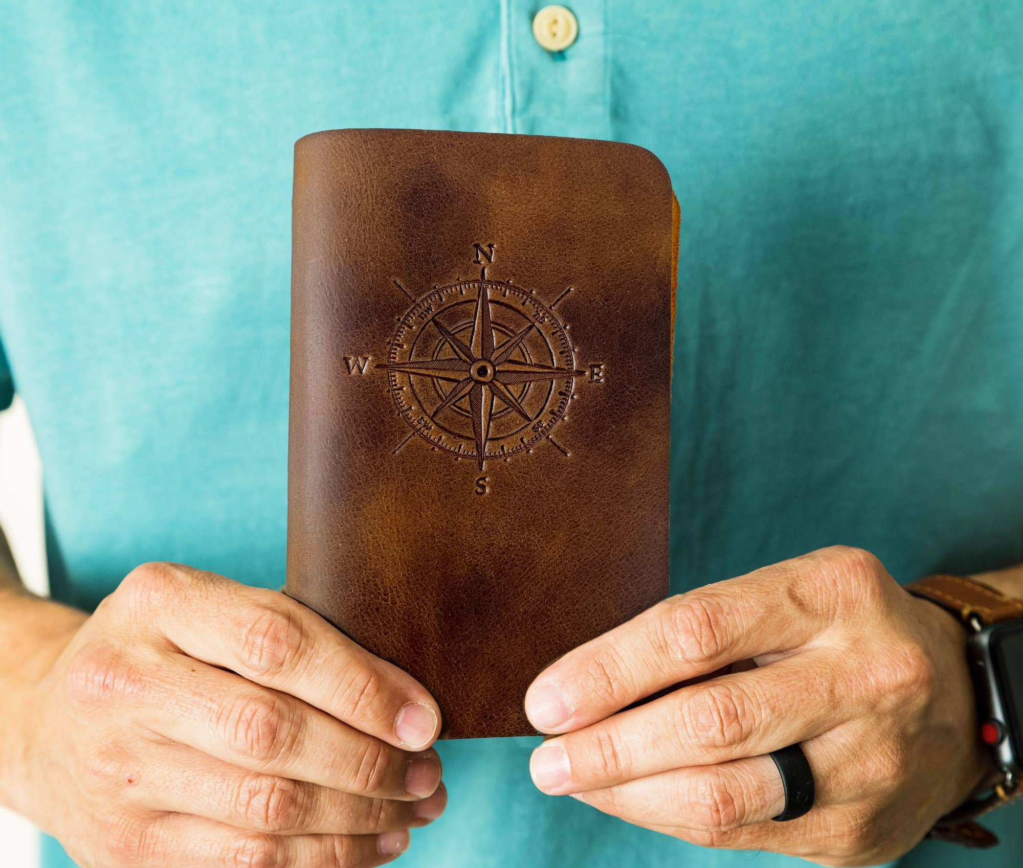 Man holding leather journal in desert sand color.