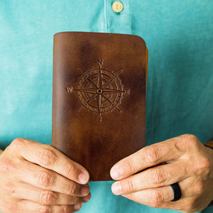Man holding leather journal in desert sand color.