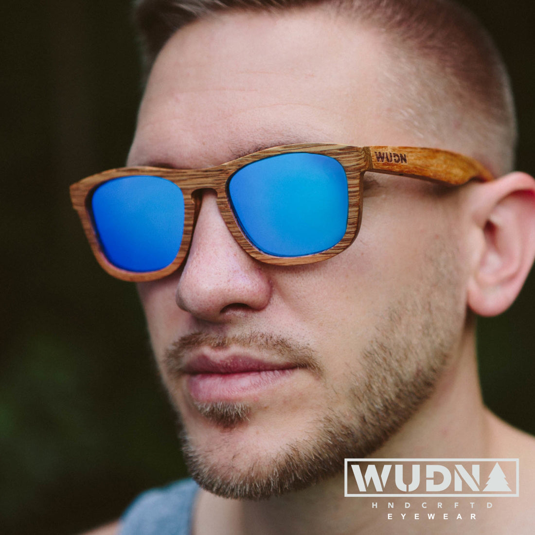 Man wearing all wood sunglasses with blue mirrored lenses