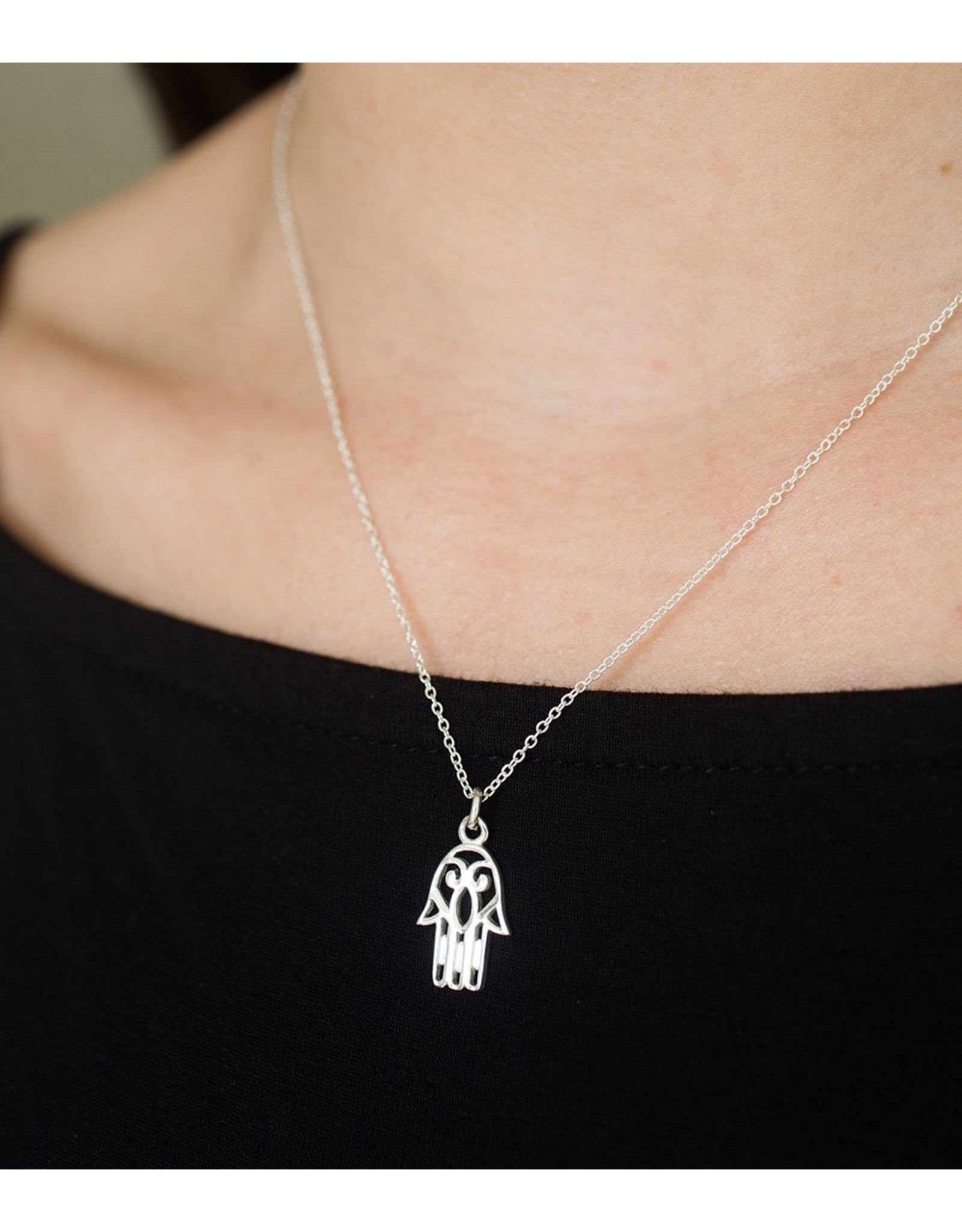 Sterling Silver charm of hamsa hand on necklace, from India shown in closeup on model.