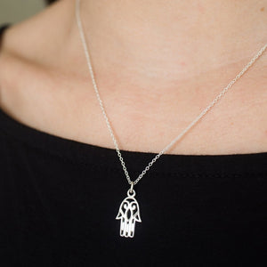 Sterling Silver charm of hamsa hand on necklace, from India shown in closeup on model.